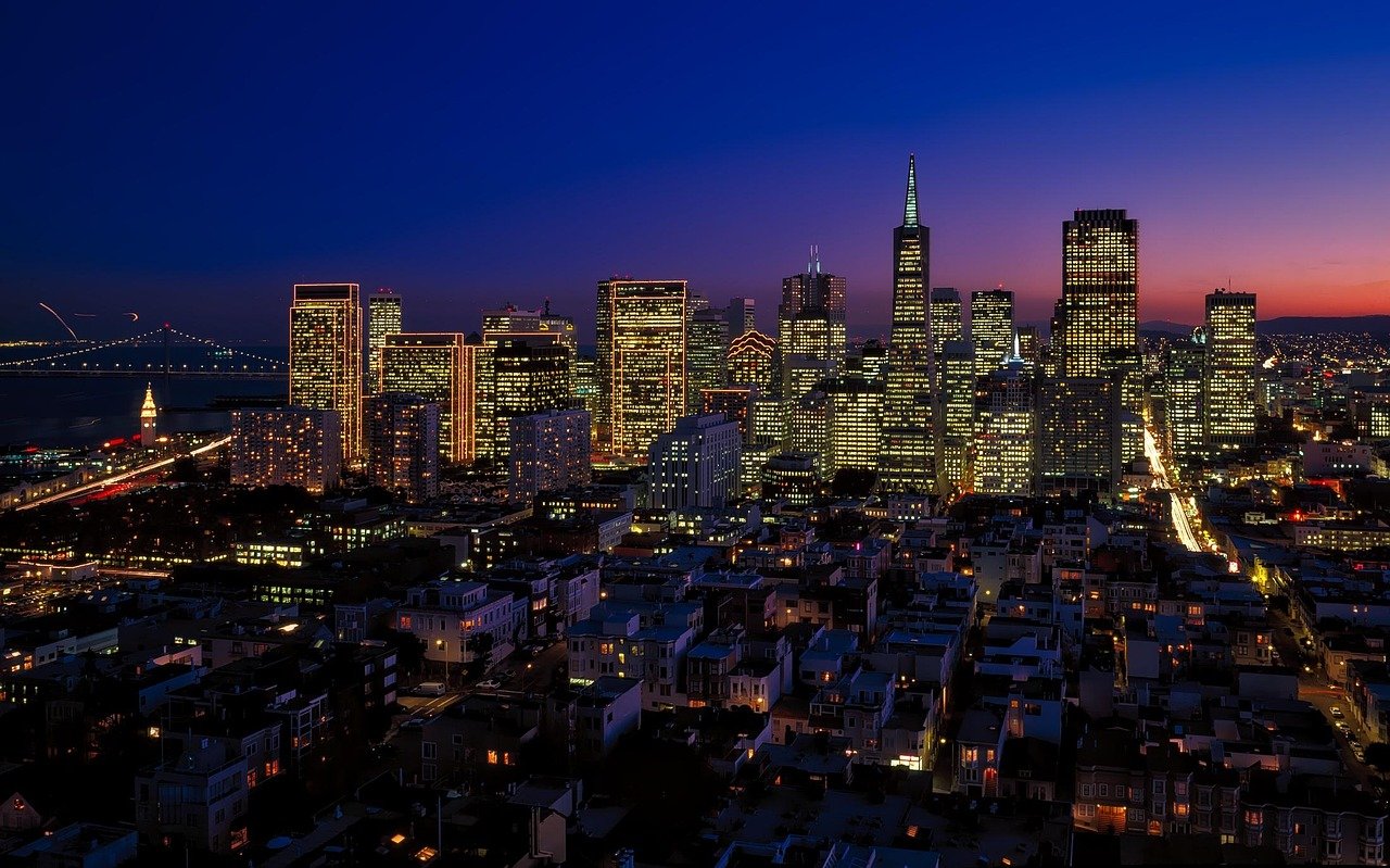 San Francisco stadsgezicht bij schemering met verlichte wolkenkrabbers en de Bay Bridge op de achtergrond