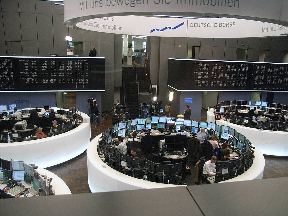 Deutsche Börse handelsvloer met koersdisplays Handelaren aan het werk bij Deutsche Börse beurs met meerdere monitoren en grote elektronische koersborden