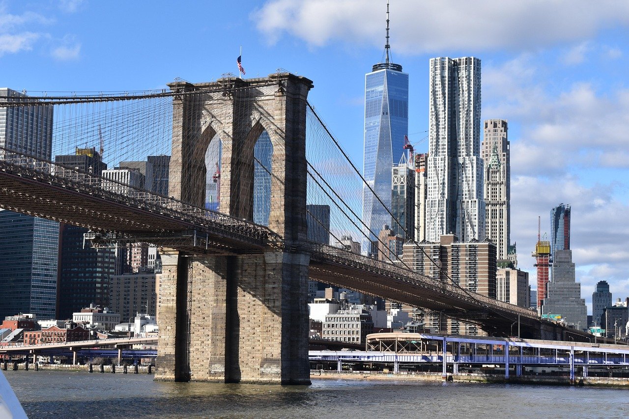 Brooklyn Bridge over de East River met de skyline van Manhattan en One World Trade Center op de achtergrond op een heldere dag