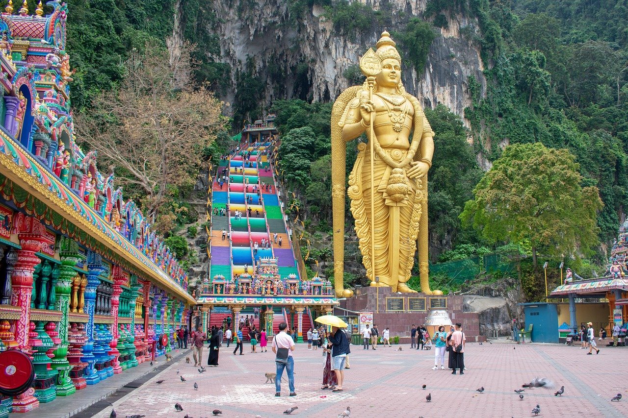 Groot gouden standbeeld van Lord Murugan bij Batu Caves met kleurrijke trappen en tempelingang in Maleisië