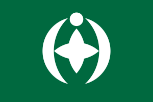 Groene vlag met wit ster- en halve maan-embleem Groene vlag met een wit cirkelvormig embleem met een stervorm en halve maanachtige krommen die eenheid en harmonie symboliseren
