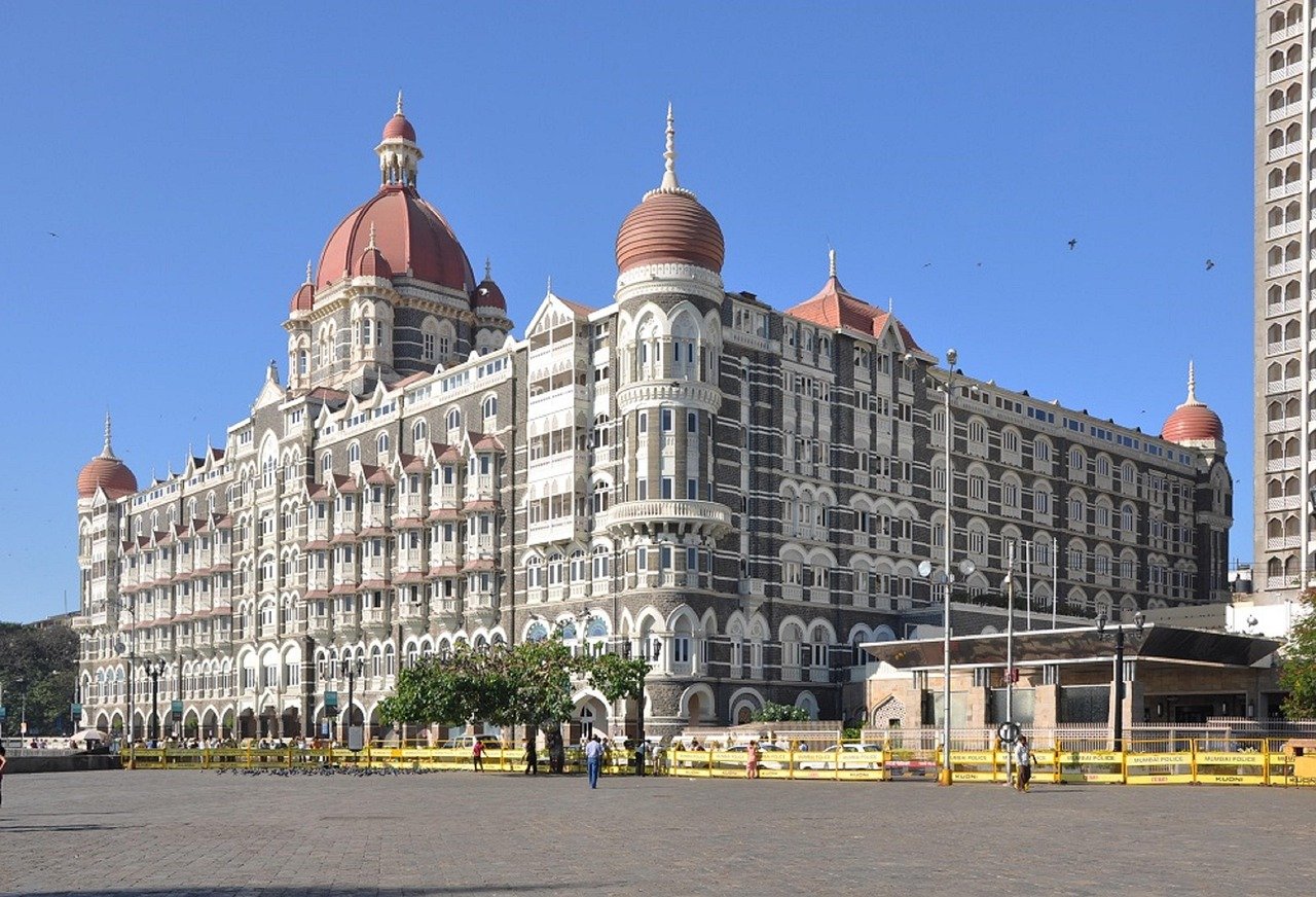 Het iconische Taj Mahal Palace Hotel in Mumbai met zijn kenmerkende koepels en koloniale architectuur onder een heldere blauwe lucht