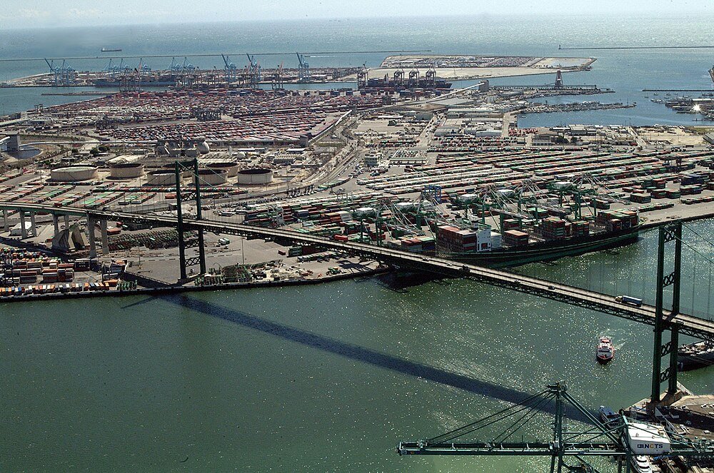 Luchtfoto van drukke haven en hangbrug Luchtfoto van een drukke haven met containerkranen, vrachtschepen en een grote hangbrug over water