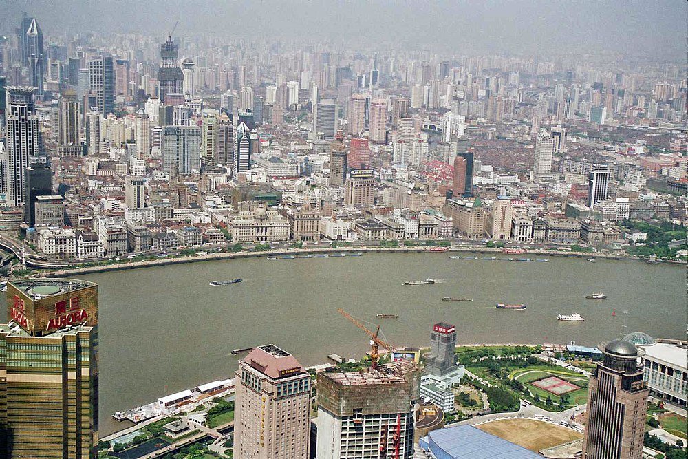 Luchtfoto van de skyline van Shanghai met de Huangpu-rivier en talrijke hoge gebouwen en boten op het water