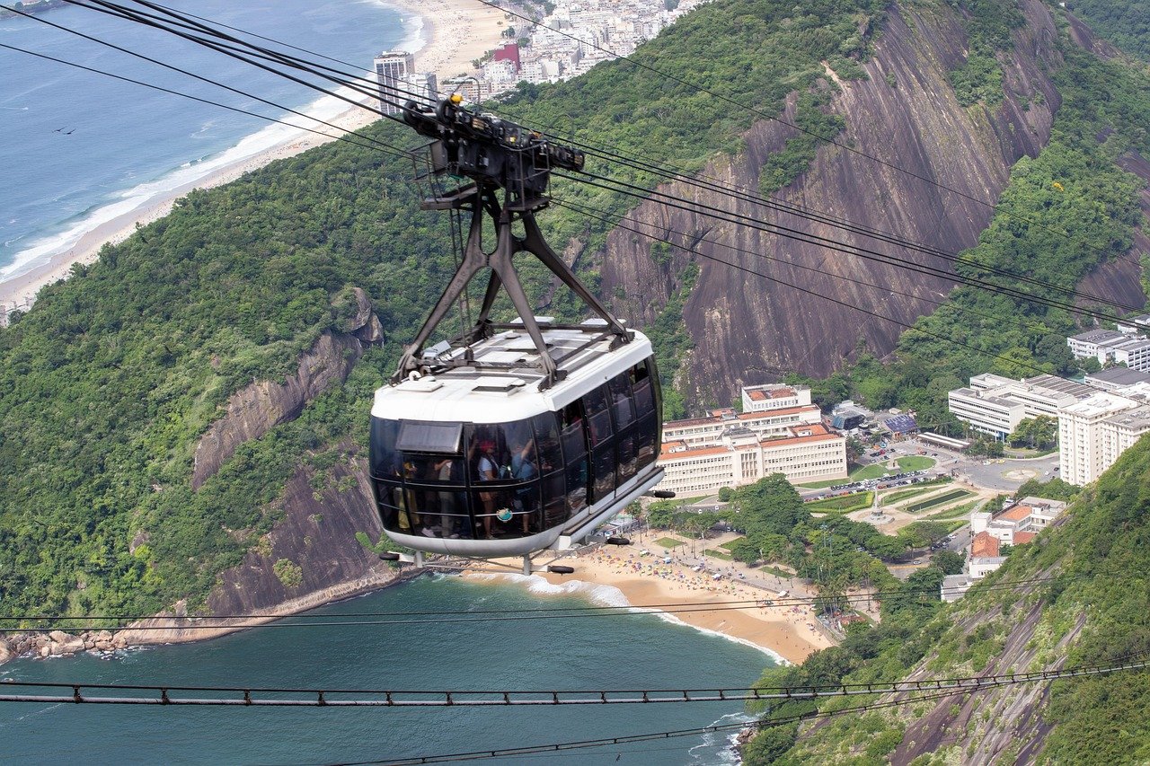 Kabelbaan die toeristen vervoert over weelderige groene bergen en stranden in Rio de Janeiro, Brazilië met uitzicht op de oceaan en de stad