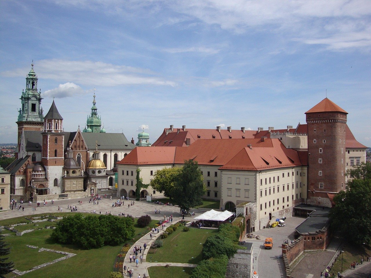Historisch Wawel Kasteel met rode daken en kathedraaltorens in Krakau, Polen, populaire toeristische bestemming met tuinen en paden.