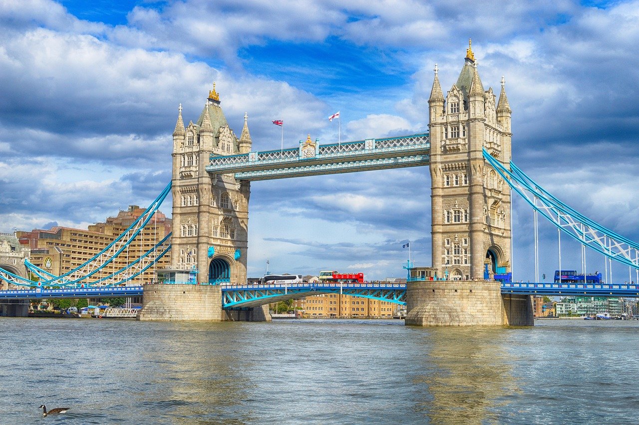 Tower Bridge in Londen over de rivier de Theems met blauwe lucht en passerende rode dubbeldekkerbus