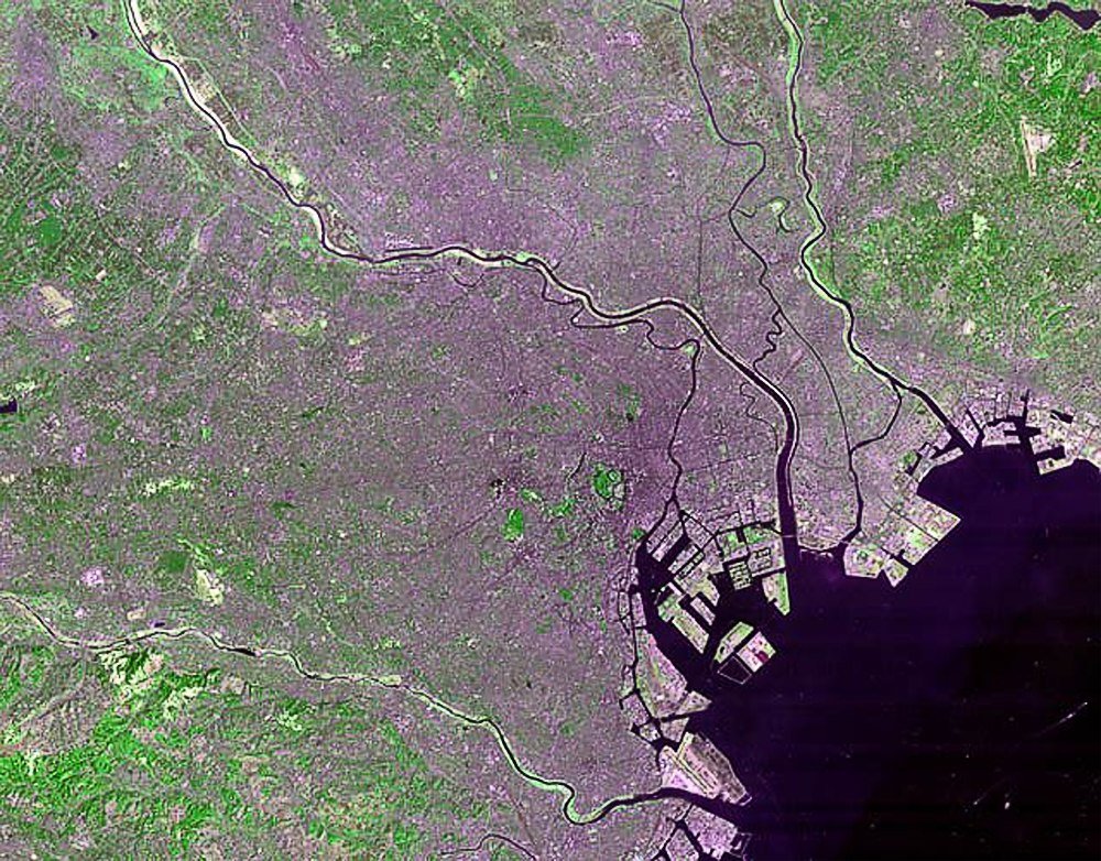 Satellietbeeld van kuststad met rivieren en stedelijke gebieden Satellietbeeld van een kuststad met rivieren, stedelijke gebieden en groene vegetatie die gedetailleerde land- en waterkenmerken toont
