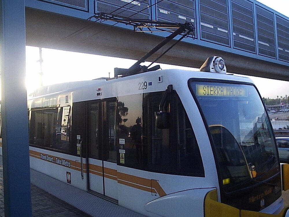 Metro Rail-trein op station met Sierra Madre bord Moderne witte en oranje Metro Rail-trein op station platform met bovenliggende elektrische draden en Sierra Madre bestemmingsbord