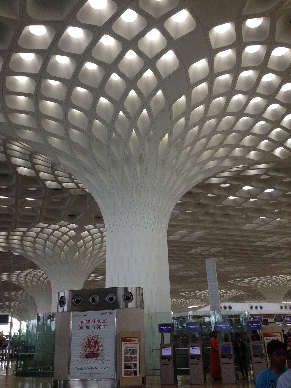 Moderne luchthaven terminal interieur met uniek honingraat plafondontwerp en zelf incheckkiosken in Terminal 2