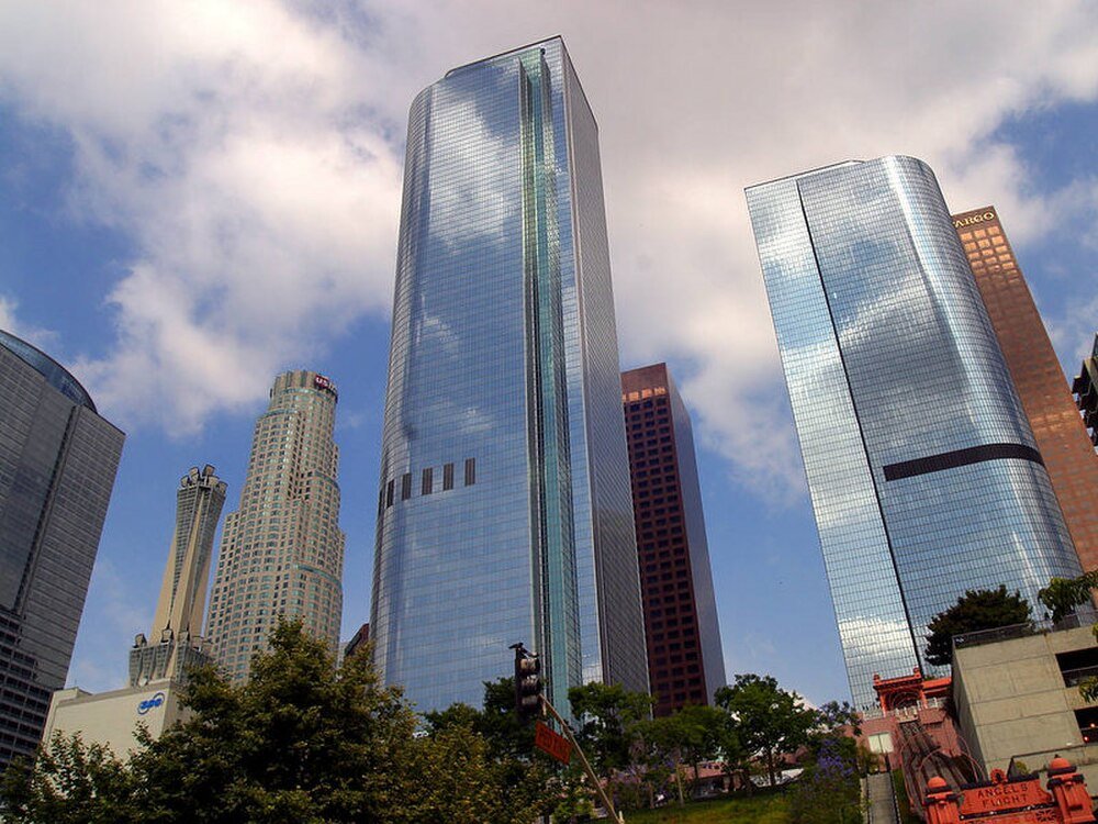 Skyline van moderne wolkenkrabbers in Downtown Los Angeles Skyline van Downtown Los Angeles met moderne glazen wolkenkrabbers onder een deels bewolkte hemel met bomen op de voorgrond