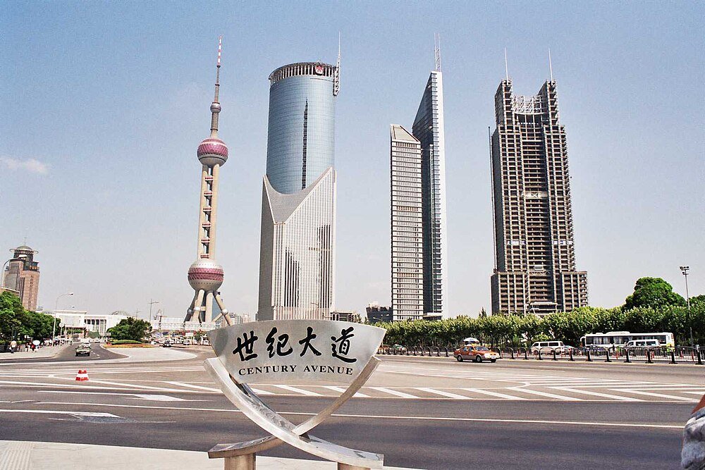 Century Avenue Shanghai skyline met Oriëntal Pearl Tower Century Avenue in Shanghai met iconische moderne wolkenkrabbers en de Oriëntal Pearl Tower onder een heldere blauwe lucht