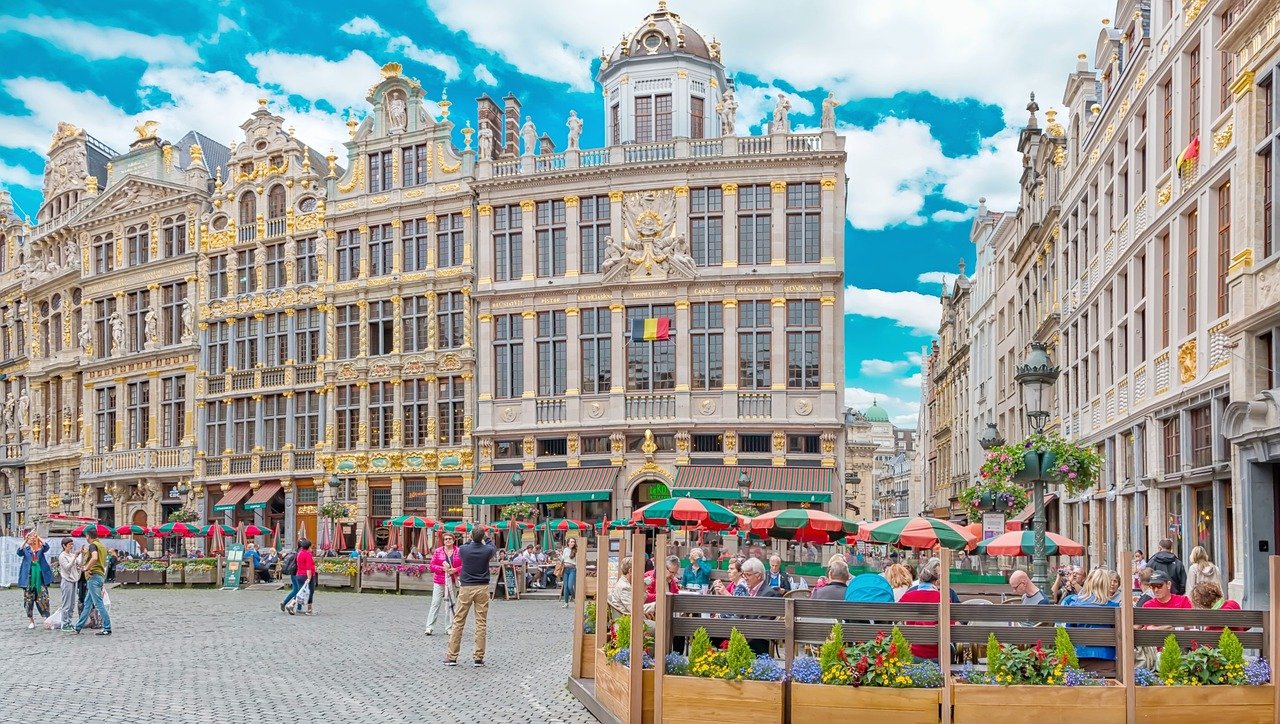 Historische Grote Markt in Brussel met sierlijke gildehuizen, buitencafés en mensen die genieten van een zonnige dag