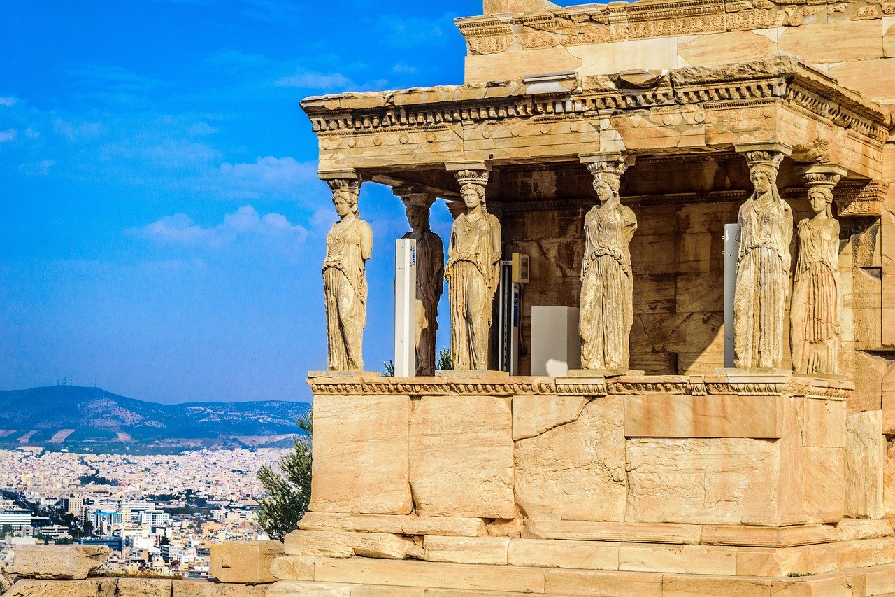 Oud-Grieks Erechtheion-tempel met Kariatidenbeelden met uitzicht op de stad Athene en blauwe lucht