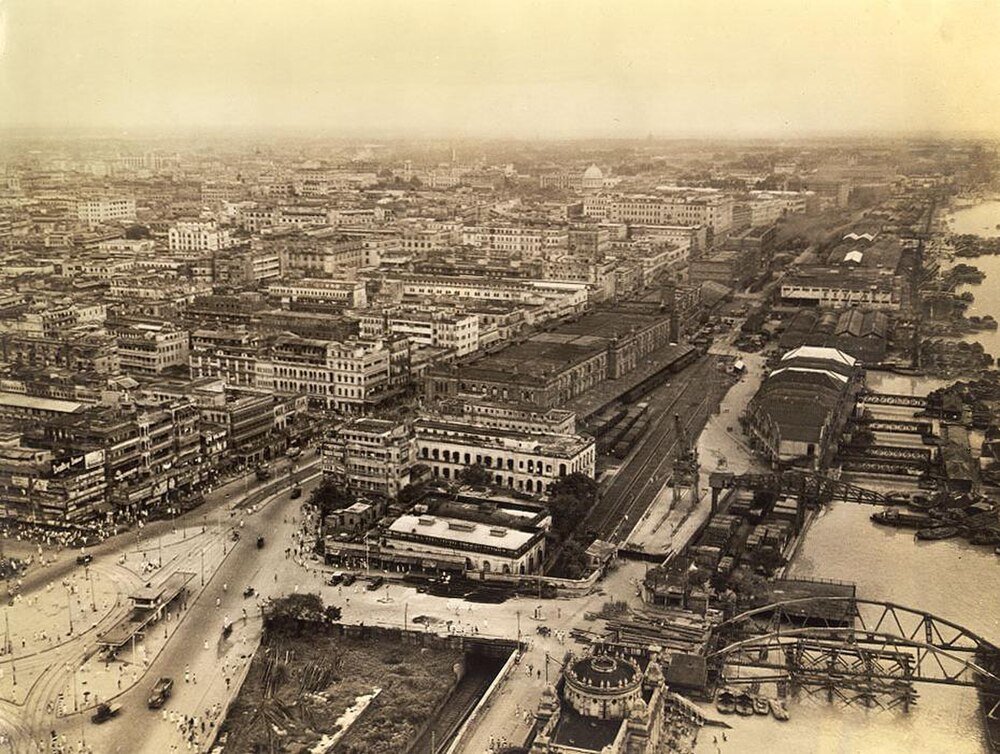 Historische luchtfoto van stad met rivier en bruggen Luchtfoto van een historische stedelijke stad met dichte gebouwen, wegen en een rivier met bruggen en boten.
