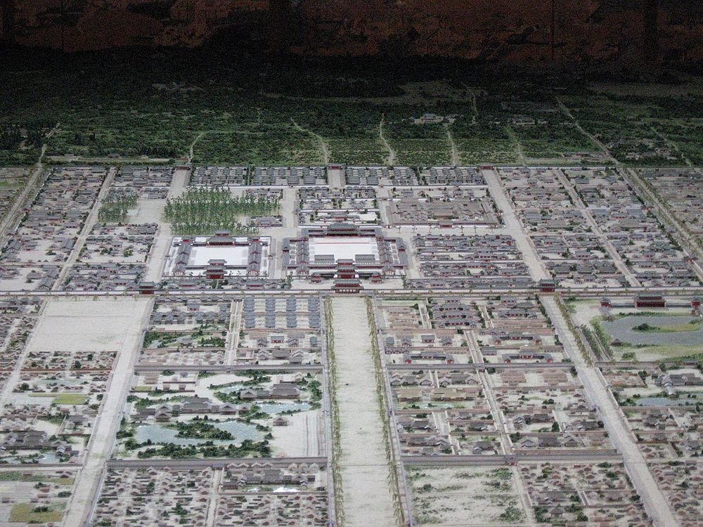 Gedetailleerd schaalmodel van een oude stadsindeling met traditionele gebouwen, straten en groen, dat historische architectuur toont.