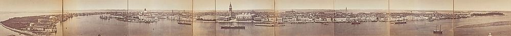 Panoramische sepia-getinte vintage foto van een historische waterkant stadsgezicht met boten en prominente gebouwen.