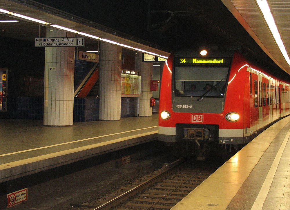 Rode DB S-Bahn trein op Duits ondergronds station Rode DB S-Bahn trein die aankomt op een Duits ondergronds station platform met borden in de Duitse taal