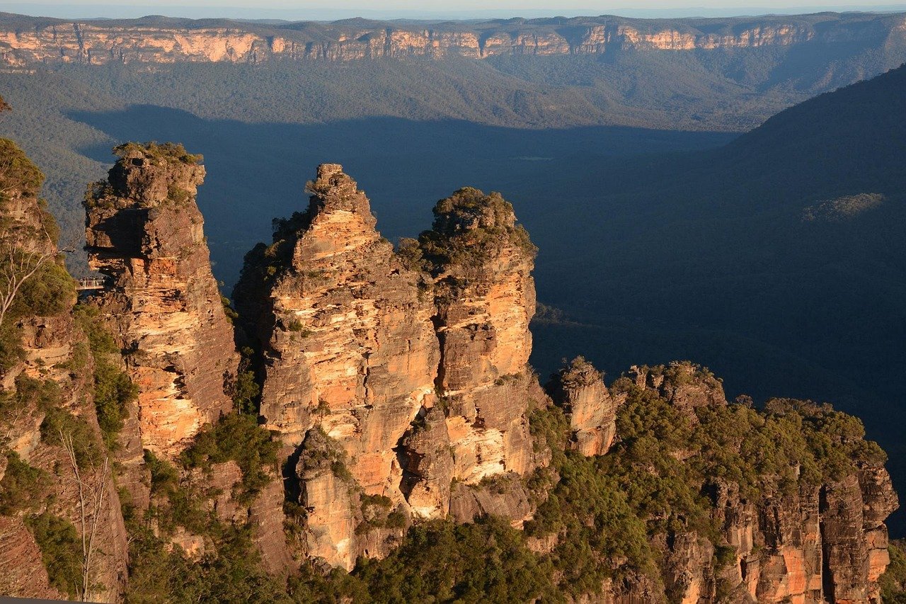 Schilderachtig uitzicht op de Three Sisters rotsformatie in Blue Mountains National Park, Australië tijdens zonsondergang met weelderig groen