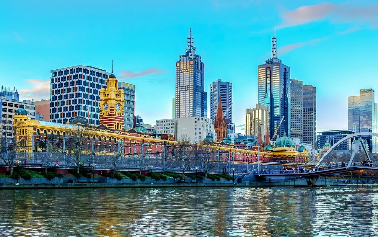 Melbourne stadsgezicht met Yarra River, Flinders Street Station en moderne wolkenkrabbers onder een heldere blauwe lucht