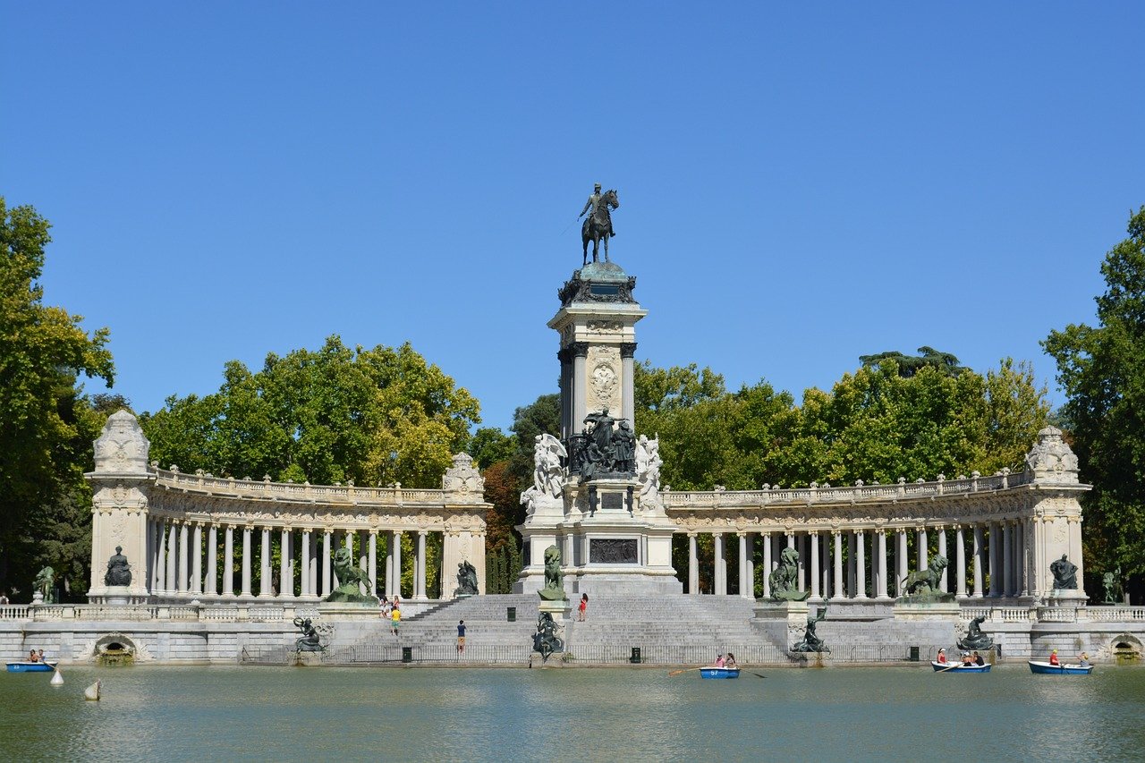 Monument met ruiterstandbeeld en zuilengalerij in Retiro Park in Madrid met mensen die op het meer varen