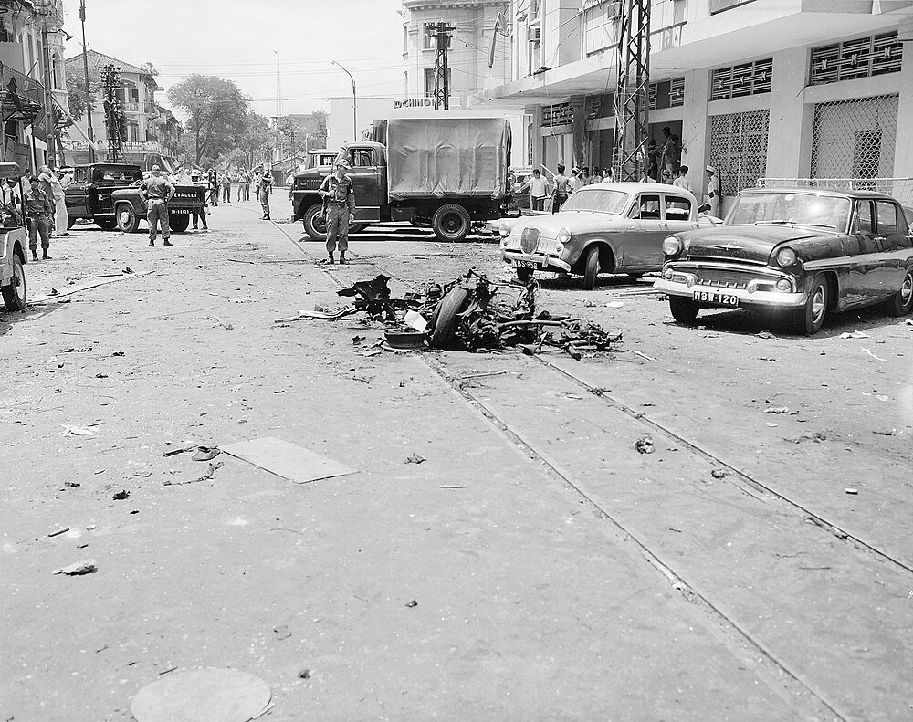 Vintage straatbeeld met soldaten en puin Zwart-wit foto van een straat met vintage auto's, puin in het midden en soldaten die rondstaan tijdens een historisch evenement