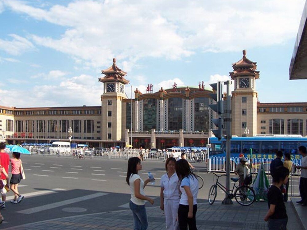 Beijing treinstation exterieur met mensen en bussen Beijing treinstation met mensen, bussen en fietsen op een zonnige dag in China