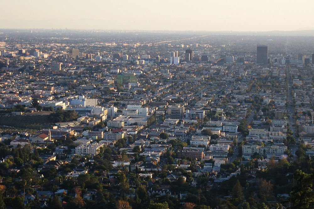 Stedelijk stadsgezicht luchtfoto bij zonsondergang Luchtfoto van een uitgestrekt stedelijk stadsgezicht met dichte gebouwen en straten onder een heldere hemel bij zonsondergang