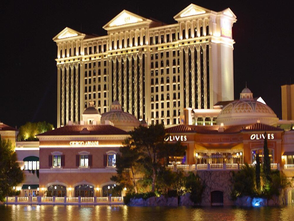 Nachtzicht van een luxe hotel en casino met verlichte klassieke architectuur en waterreflectie