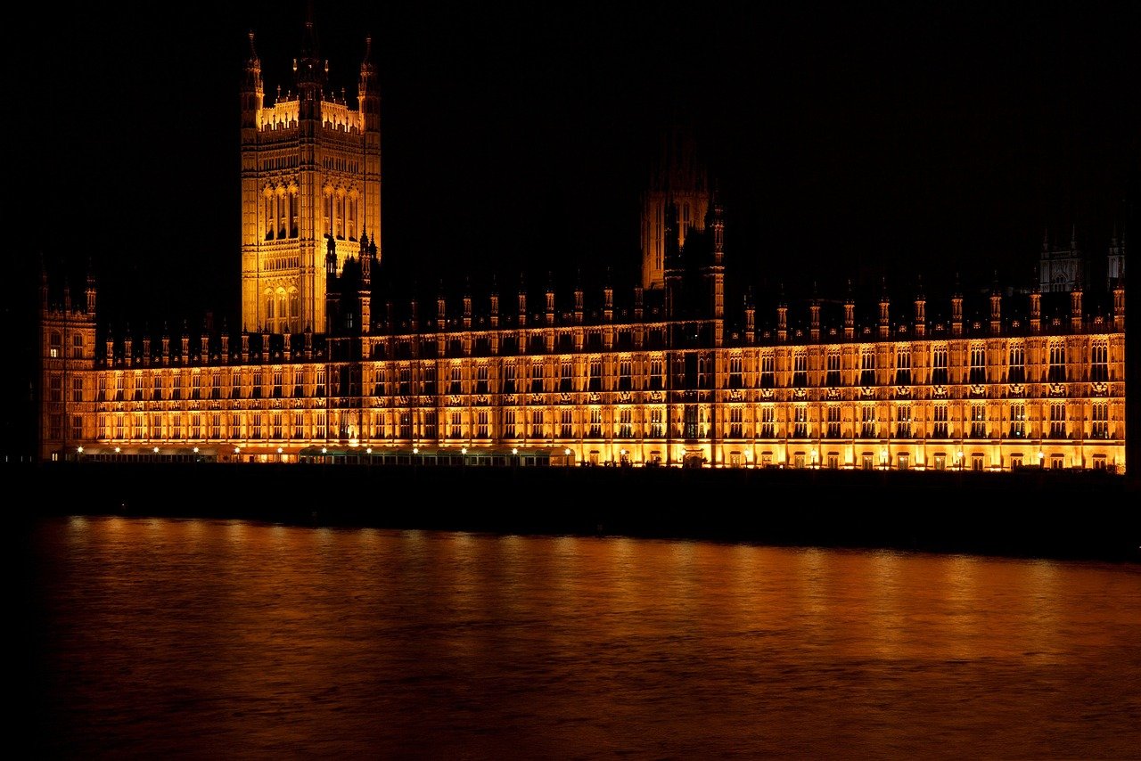 Verlicht Paleis van Westminster 's nachts weerspiegeld op de Theems in Londen, iconisch Brits monument en overheidsgebouw