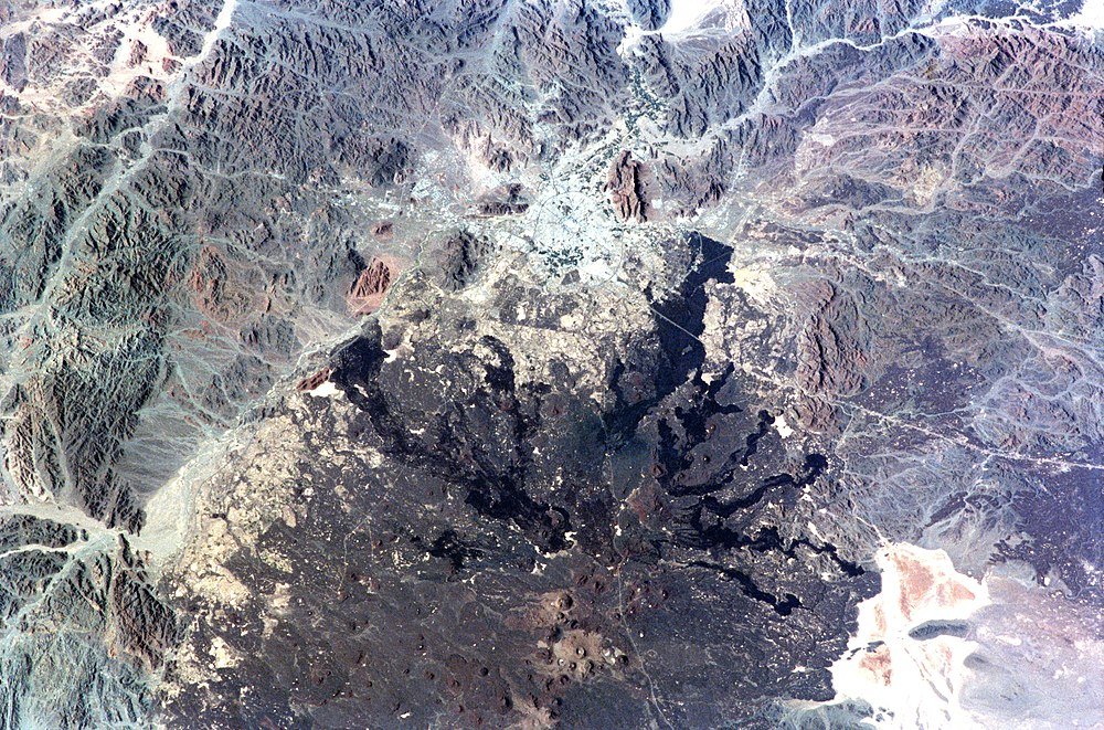 Luchtfoto van vulkanische krater en bergen Luchtfoto van een vulkanische krater omgeven door ruig bergachtig terrein en schaarse vegetatie