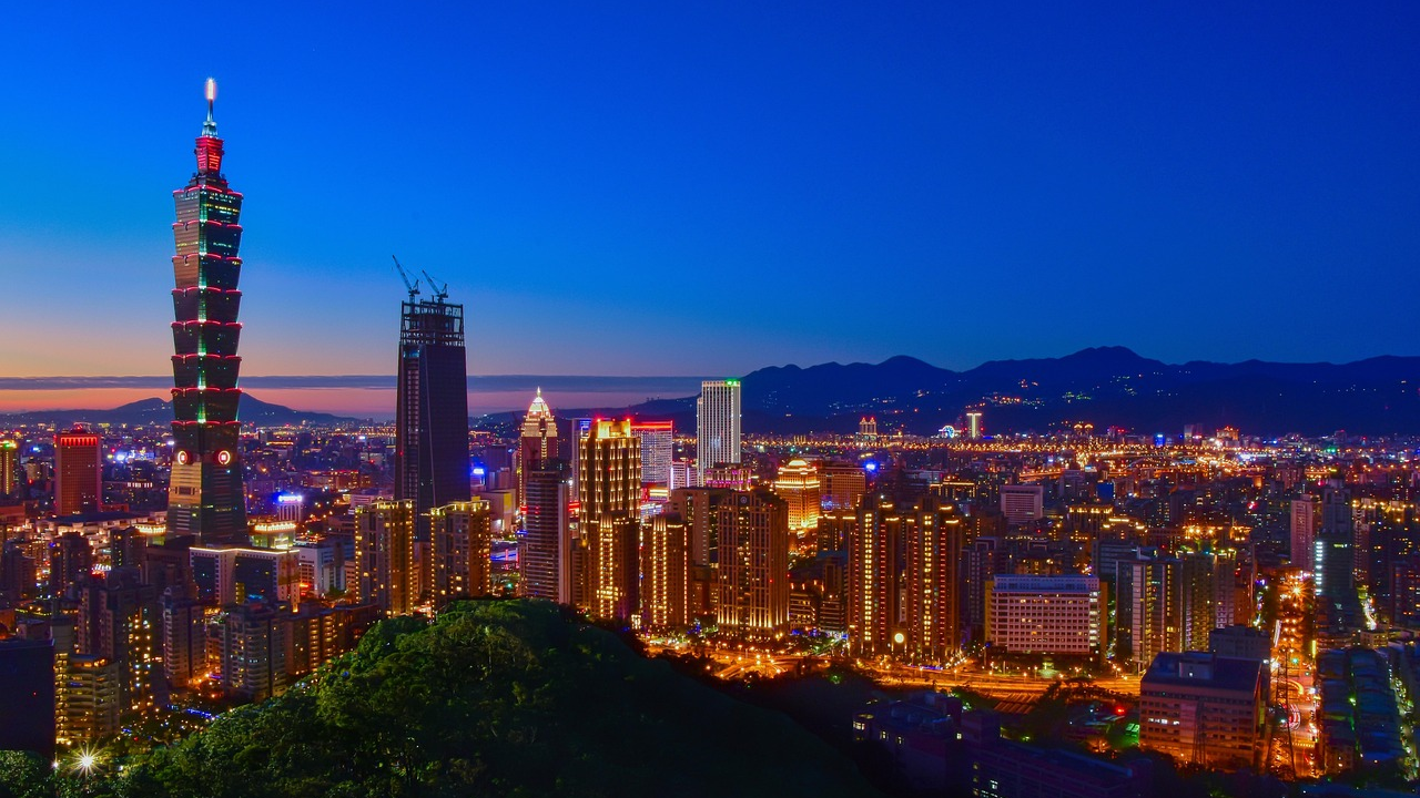 Skyline van de stad Taipei met Taipei 101 's nachts Nachtelijke skyline van de stad Taipei met verlichte Taipei 101 toren en omliggende gebouwen onder een heldere blauwe lucht