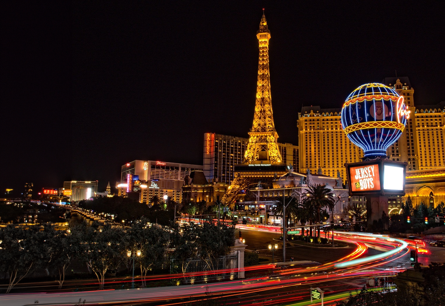 Las Vegas Strip 's Nachts met Eiffeltoren Replica Nachtzicht op de Las Vegas Strip met verlichte replica van de Eiffeltoren en levendige neonborden die casino's en entertainment tonen.