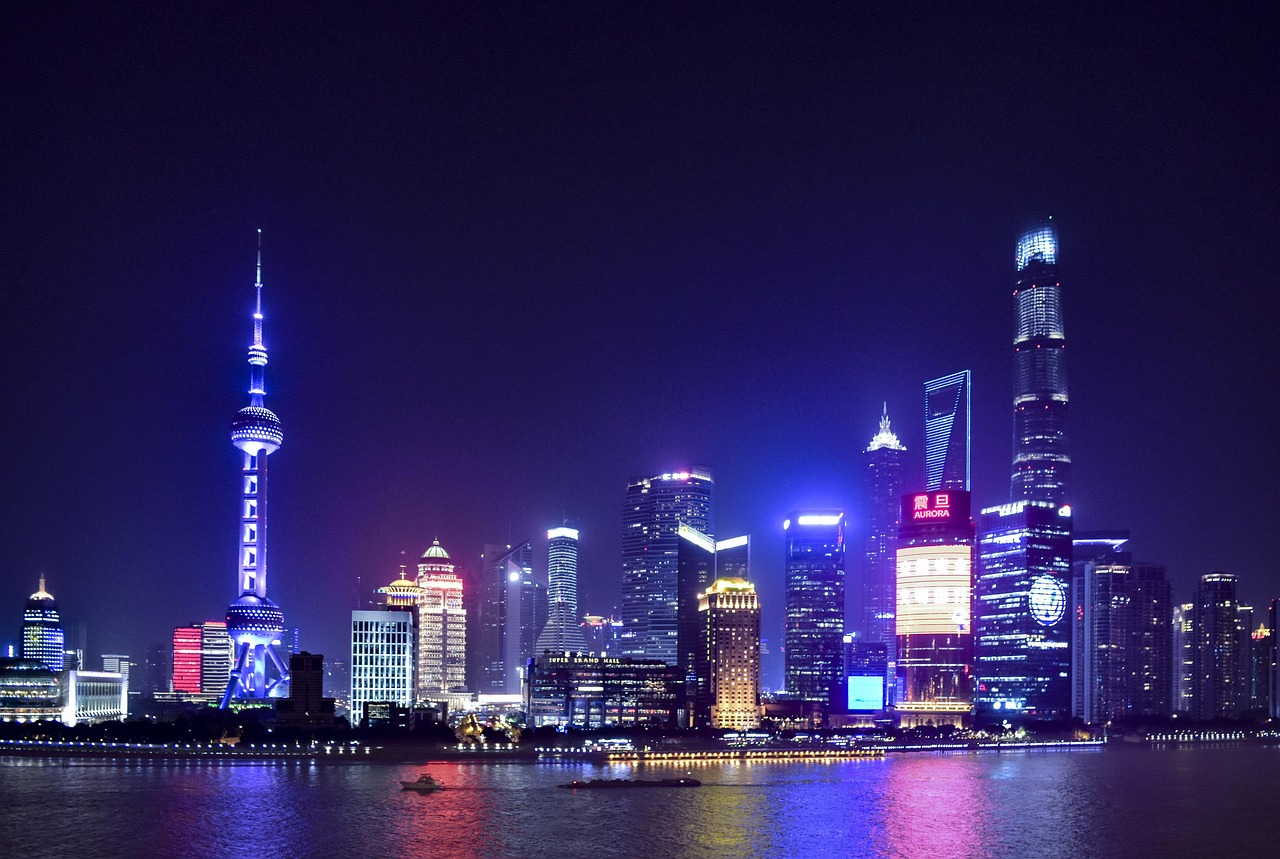 Skyline van Shanghai 's nachts met gloeiende wolkenkrabbers Nachtzicht op de skyline van Shanghai met verlichte wolkenkrabbers en reflecties op de Huangpu-rivier
