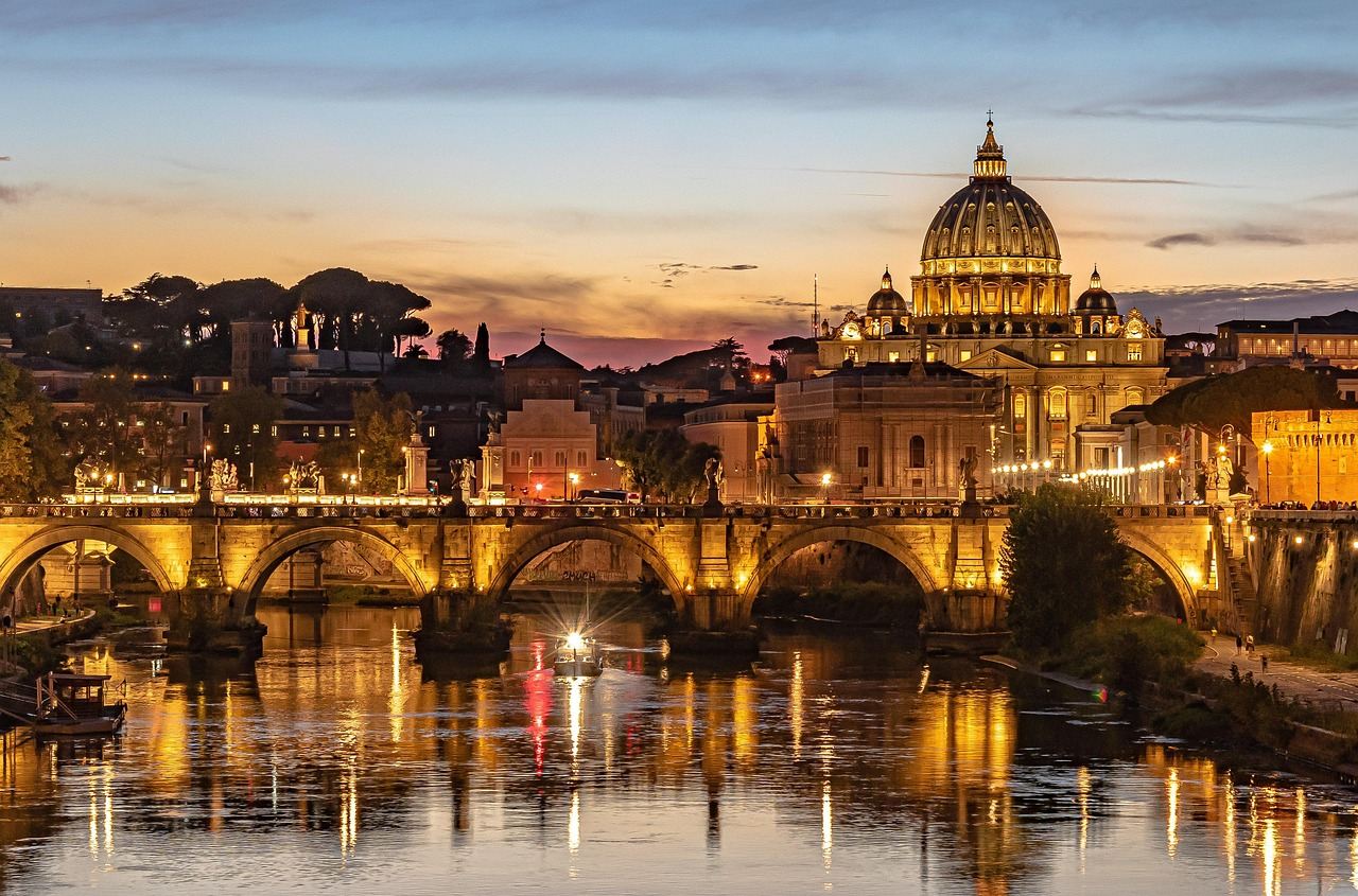 Zonsondergang bij de Sint-Pietersbasiliek en Ponte Sant'Angelo, Rome Adembenemend uitzicht op de zonsondergang van de Sint-Pietersbasiliek en de Ponte Sant'Angelo brug over de Tiber in Rome, Italië