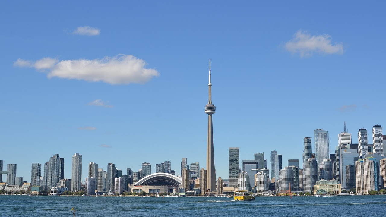 Skyline van Toronto met CN Tower en waterkant Skyline van de stad Toronto met de CN Tower en de waterkant op een heldere zonnige dag met blauwe lucht en verspreide wolken