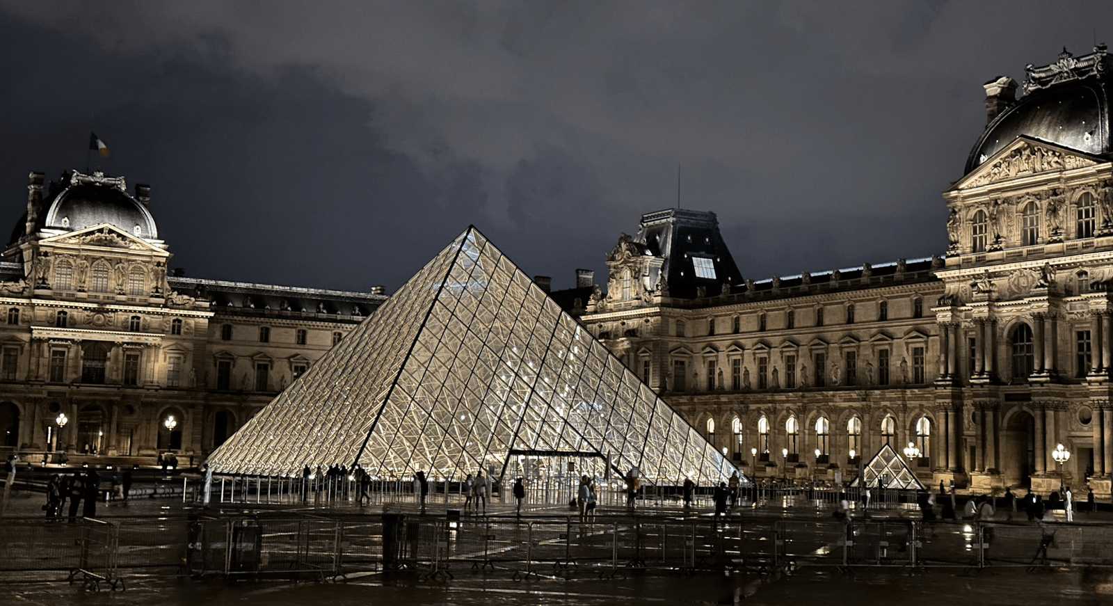 Louvre Museum Glazen Piramide 's Nachts Verlichte glazen piramide-ingang van het Louvre Museum 's nachts met historische Parijse architectuur op de achtergrond