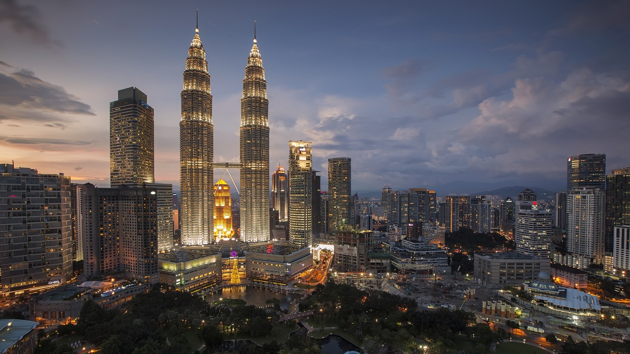 Skyline van Kuala Lumpur met Petronas Twin Towers 's nachts Nachtzicht op de skyline van Kuala Lumpur met verlichte Petronas Twin Towers en omliggende wolkenkrabbers