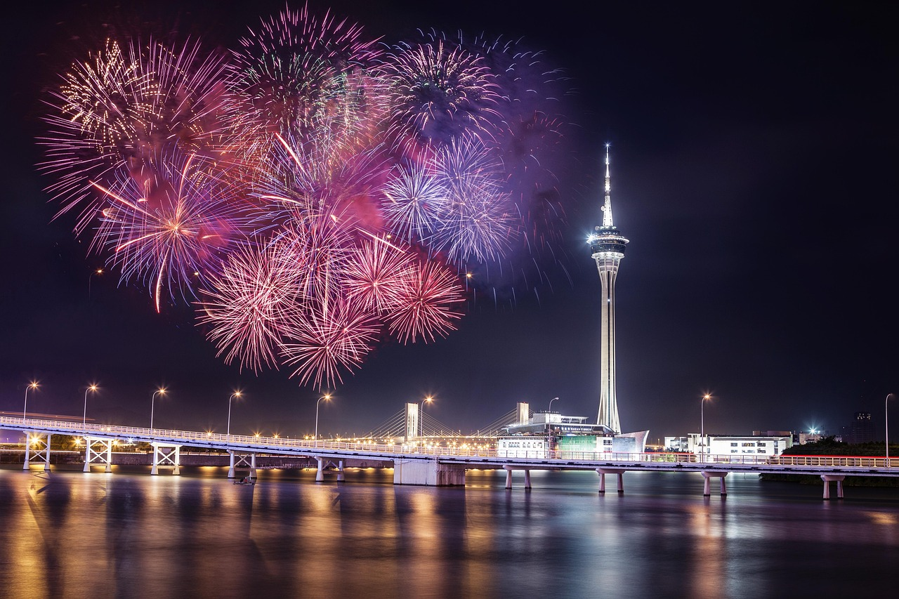 Vuurwerk boven stadsgezicht met verlichte toren Kleurrijke vuurwerkshow boven een moderne stadsgezicht met een hoge verlichte toren en brug 's nachts