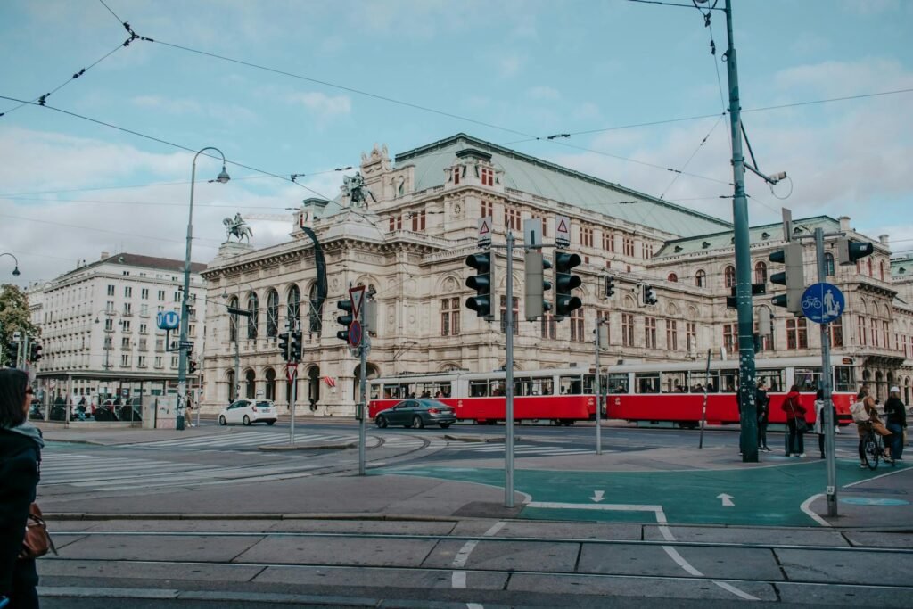 Het gebouw van de Weense Staatsopera met een passerende rode tram, historisch en modern verweven