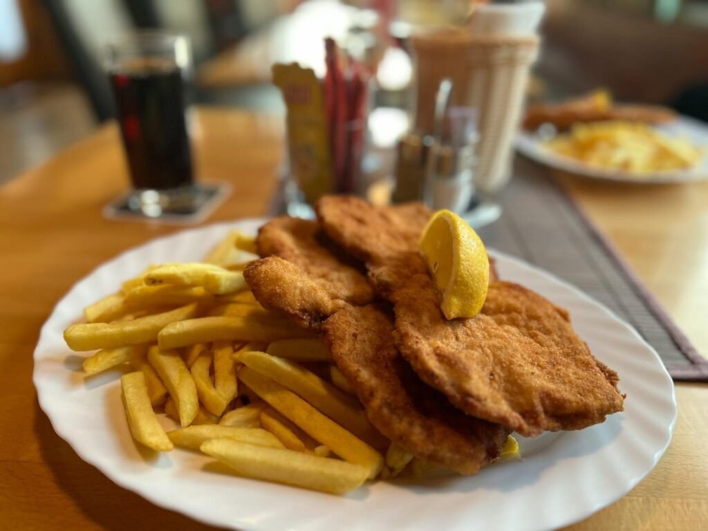 Een traditionele Wiener Schnitzel met frietjes en citroen in een gezellig Weens restaurant